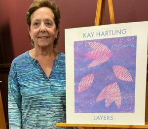 Artist Kay Hartung by the entrance to her exhibit at the Acton Memorial Library. 