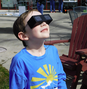 A Discovery Museum visitor wearing protective glasses