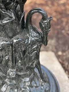 A Victorian-era cast zinc fountain planted with colorful flowers.