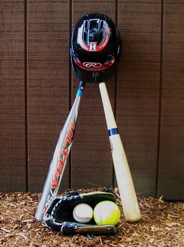 A baseball bat, ball, and glove are on the ground.