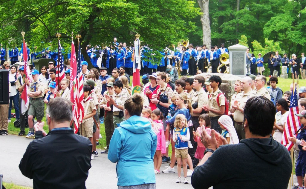 Boy and girls scouts of all ages listen to the Memorial Day speeches. Select board members are in the foreground (facing the podium), and the ABRHS band stands in the background.