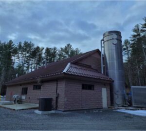 A brick building with a large metal silo attached.