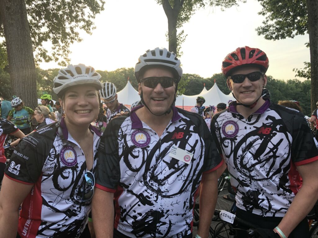 Three people in black and white Pan-Mass Challenge jerseys are ready to start the long ride.