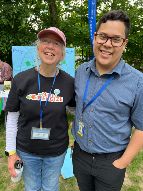 A man and a woman smiling in the sun. The woman is wearing a MassEnergize t-shirt.