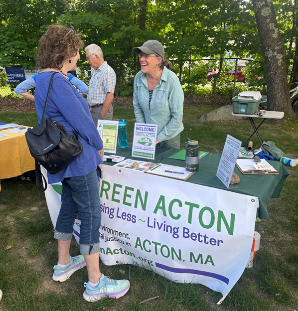 A woman at the Green Acton booth speaks to a fair attendee.