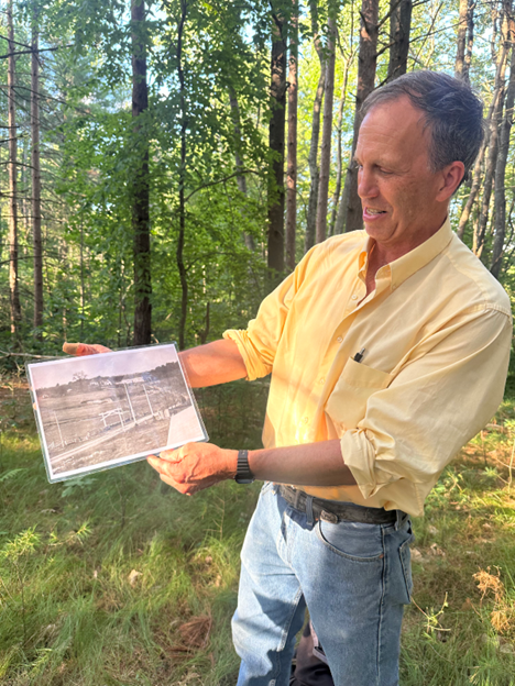 A man shows an old black and white picture.