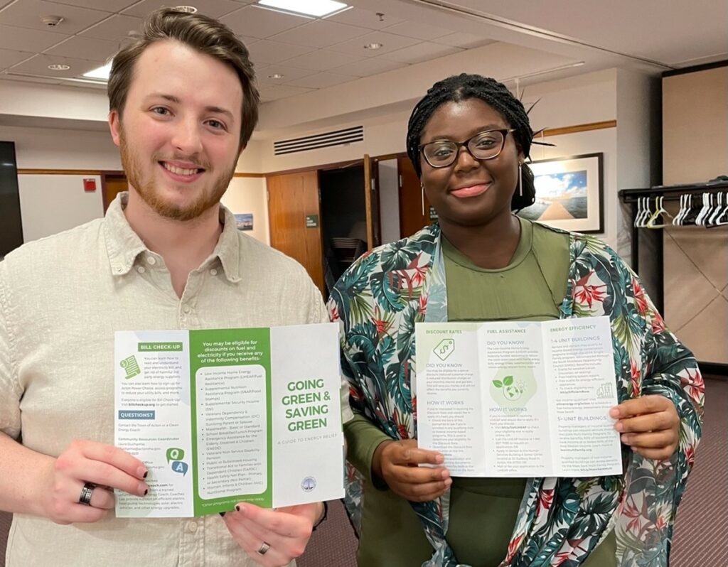 Two young adults show the Going Green and Saving Green pamphlet.