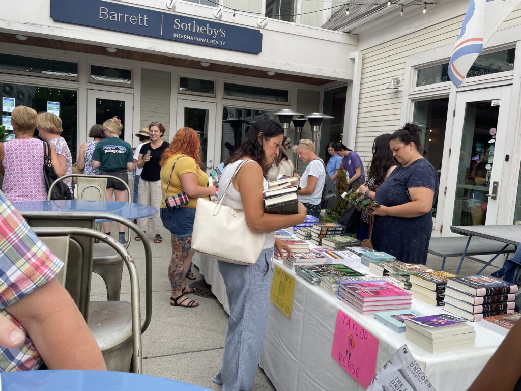 People browsing tables full of books set up outside.