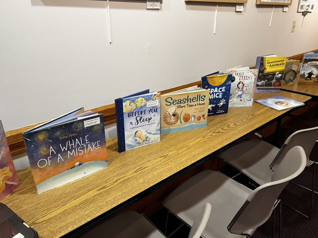 Several children's books lined up on a table.