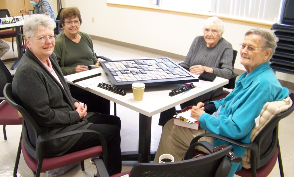 Four women playing Scrabble at the Council on Aging. At least one of them has an unfortunate collection of letters.