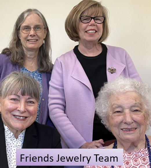 Four women, two standing, two sitting, pose for this photo.