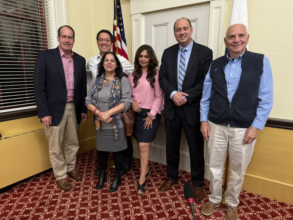 A group of people standing in front of an American flag.