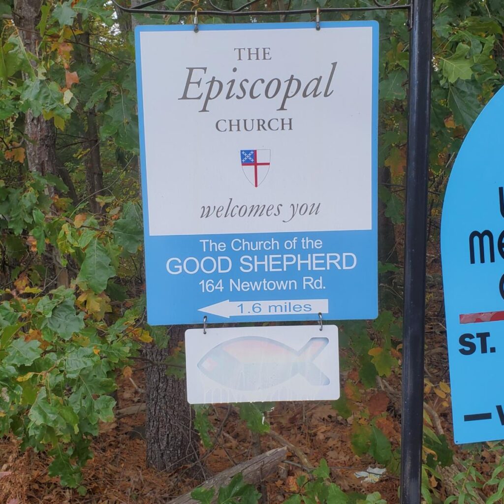 A church sign with a white stylized fish panel below it.