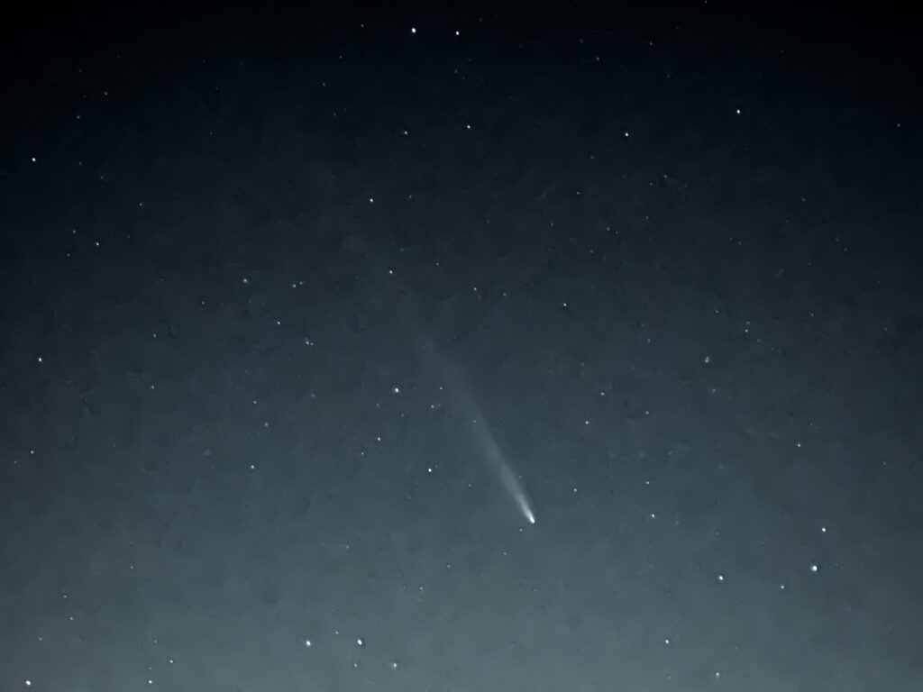 A starry night with the comet clearly seen as a streak of light across the sky.