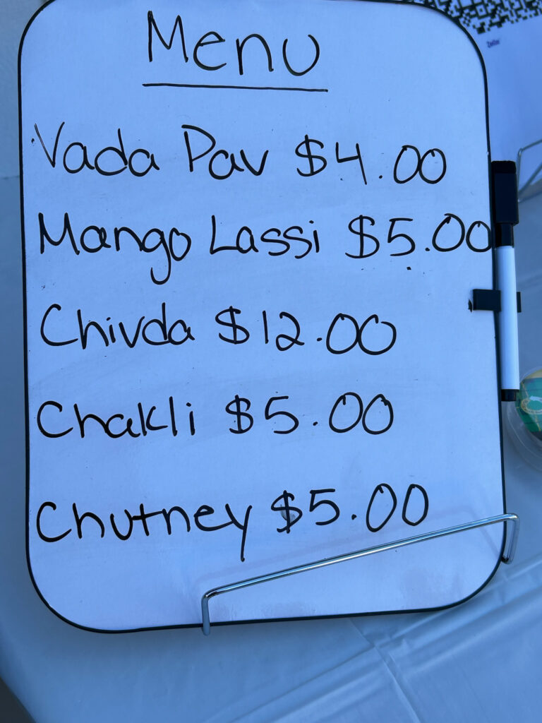 A menu from one of the food booths selling distinctly Indian treats -- Vada Pav, Mango Lassi, and more.