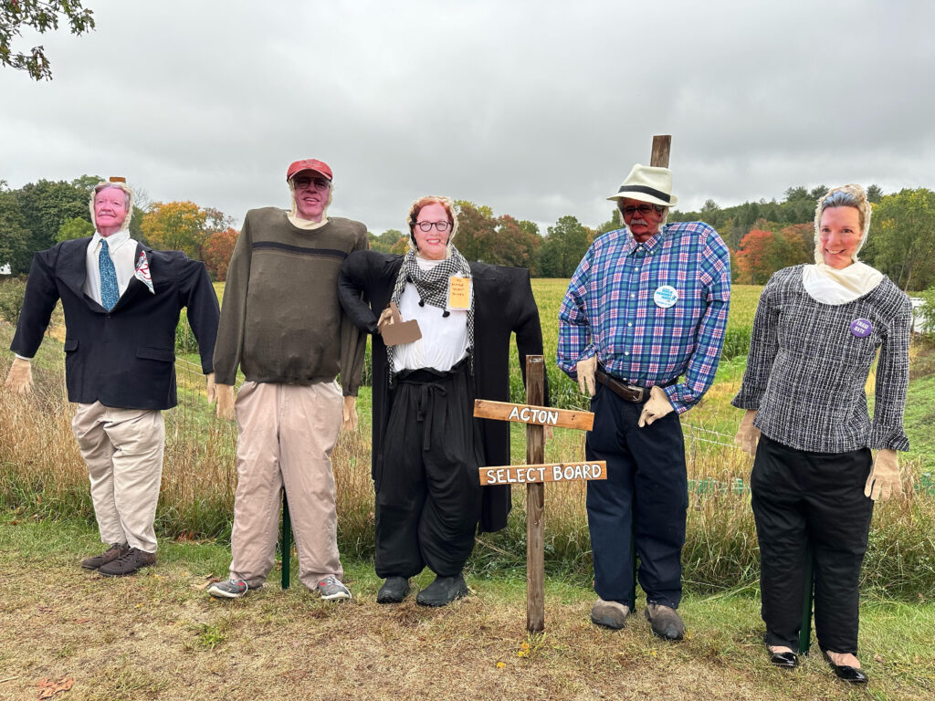 Select Board members, as scarecrows ,are appropriately clad:

* Dean Charter wears a blue sports jacket and a large Acton 250 sign.
* Jim Snyder-Grant sports a typical Jim sweater and baggyy chinos.
* Fran Arsenault wears a white shirt, long sweater, and a sporty scarf.
* David Martin wears a hat and a plaid button-down shirt.
* Alissa Nicol is fashionably clad in a plaid sweater and slacks. 