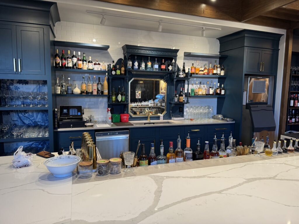 A fully stocked bar with a white marble counter.