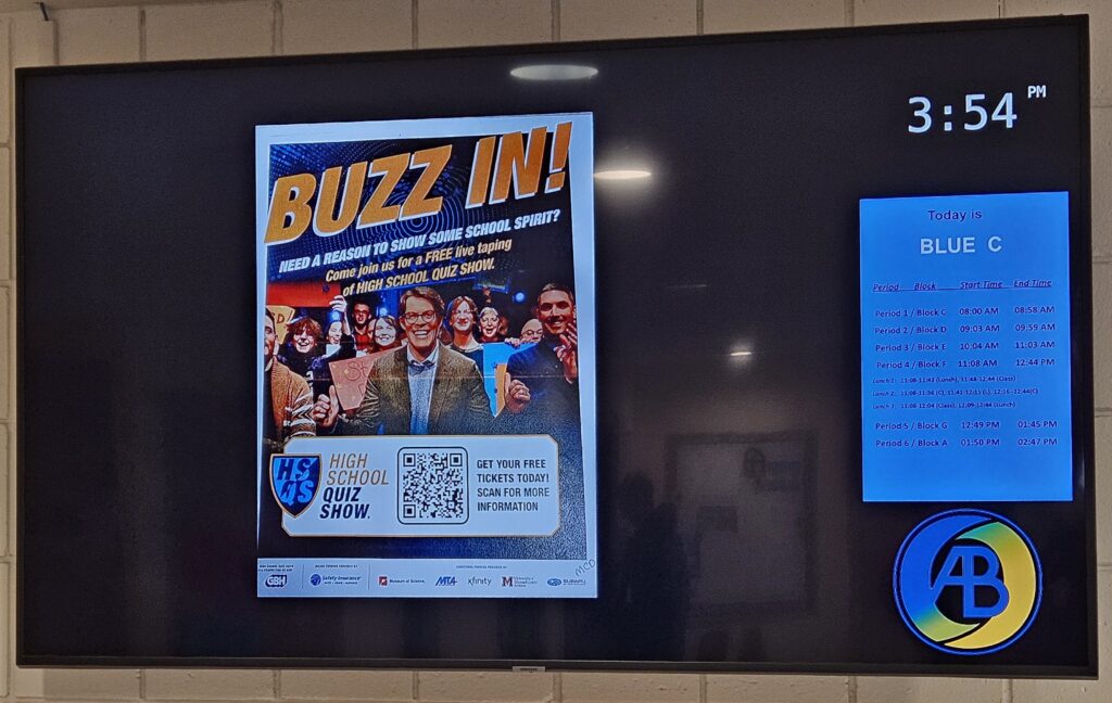 On one of the school's bulletin boards, a BUZZ IN! poster advertising the High School Quiz Show.