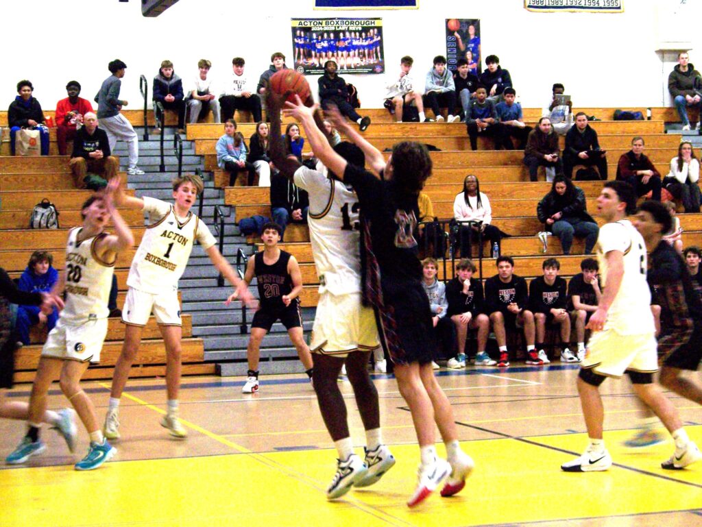 A Weston player tries to grab the ball from behind an AB player.