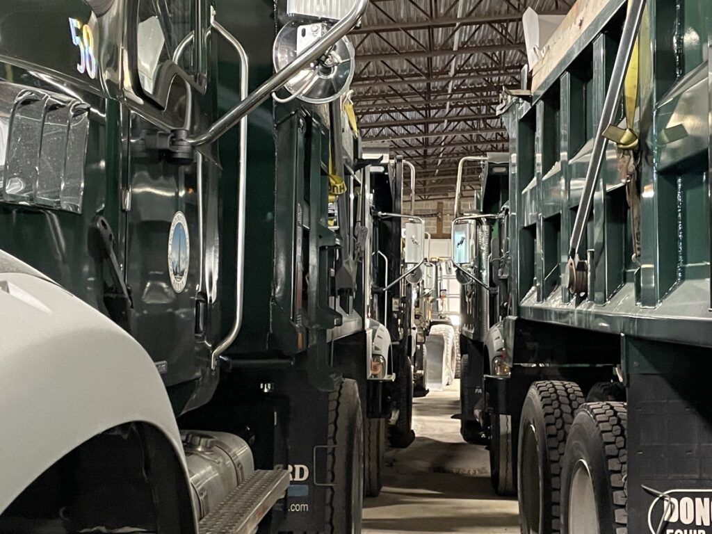 Two lines of very large trucks with a narrow path in the middle.