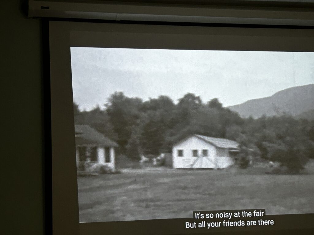 An old 'black and white' photograph of a small building from a slight distance.