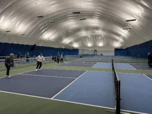 People playing pickleball under a very large bubble.